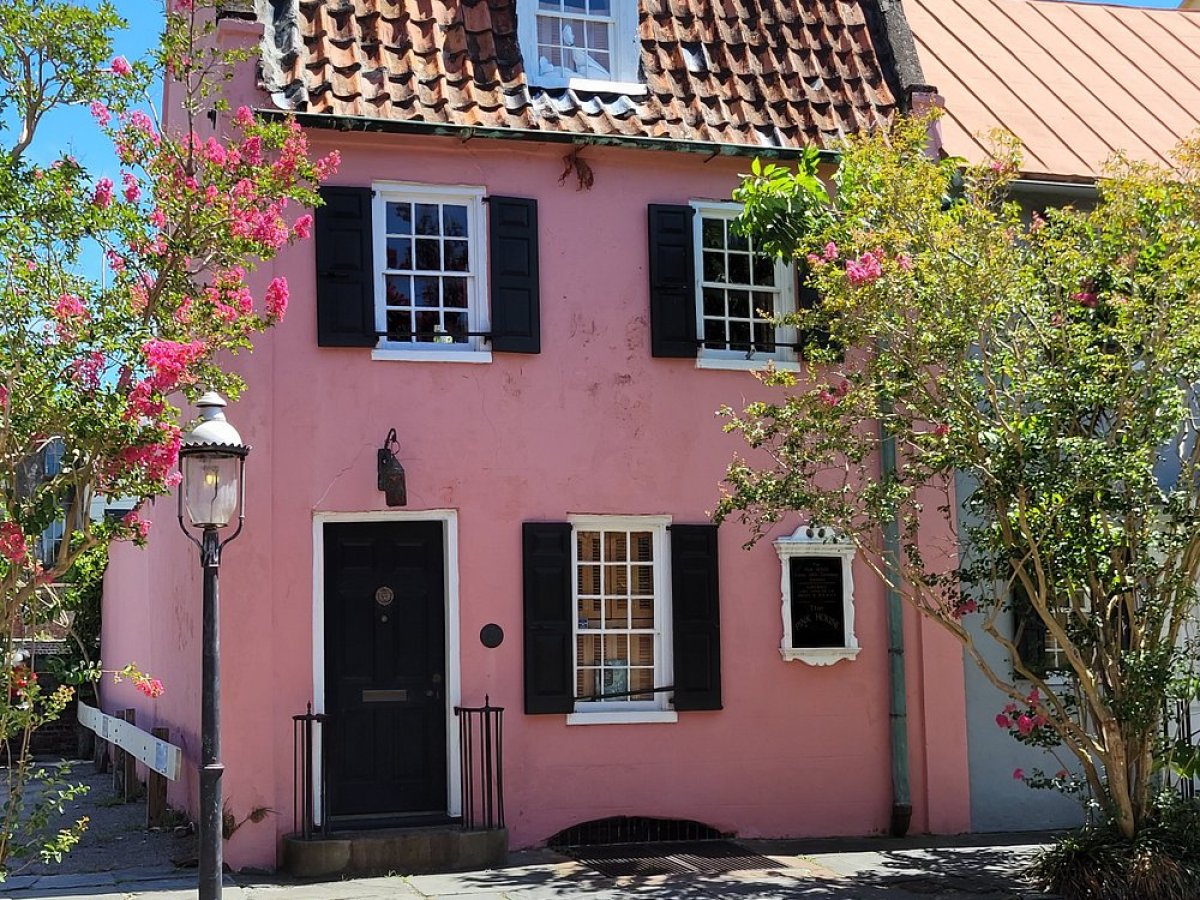 a house with bushes in front of a brick building