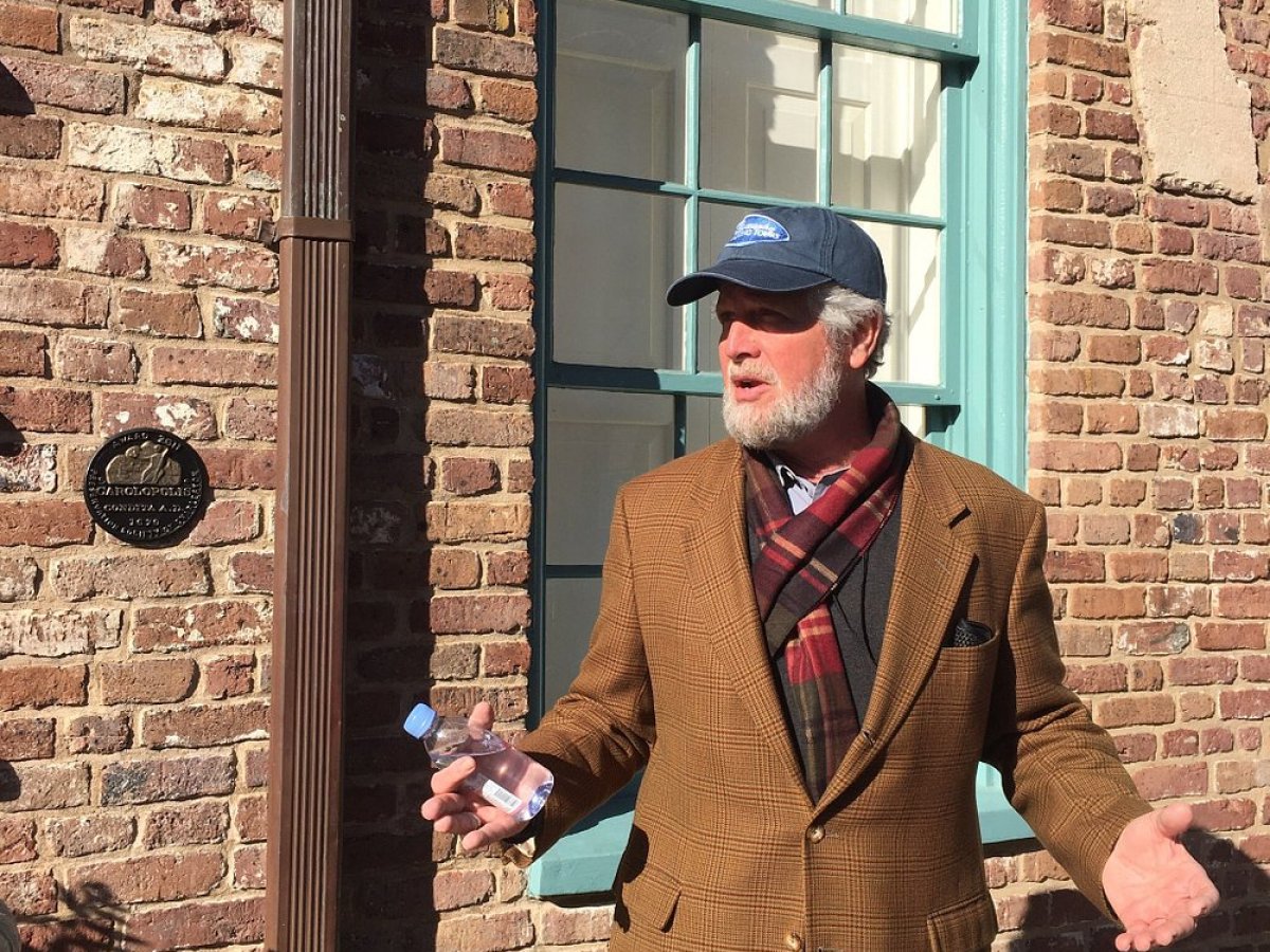 a man standing in front of a brick building